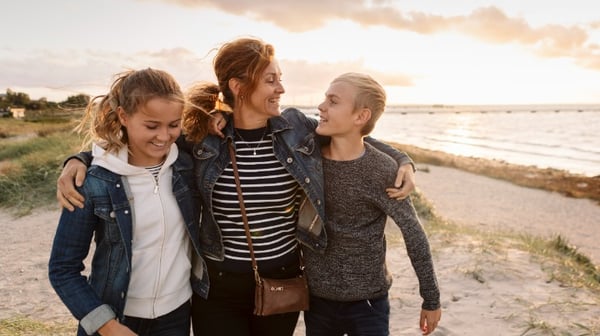 Mother with children walking on the beach