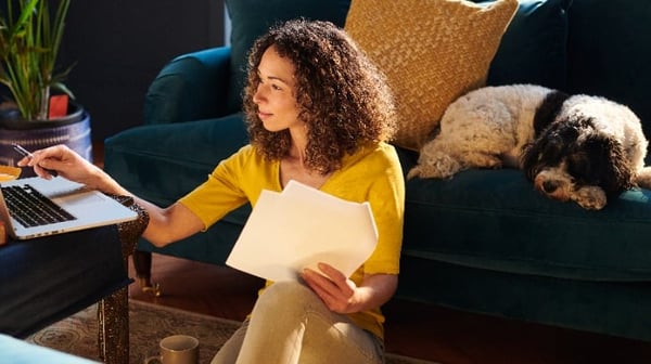 Woman sitting at her laptop with dog in living room