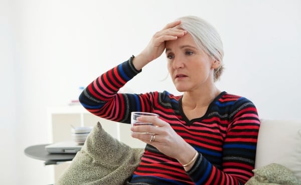 Woman feeling warm holding a glass of water