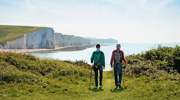 Two people walking along a coastal path