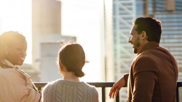 Three people standing on a bridge