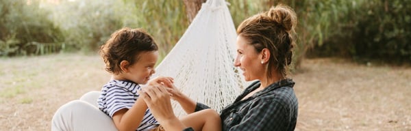 Mother and son outside sitting happily in a hammock