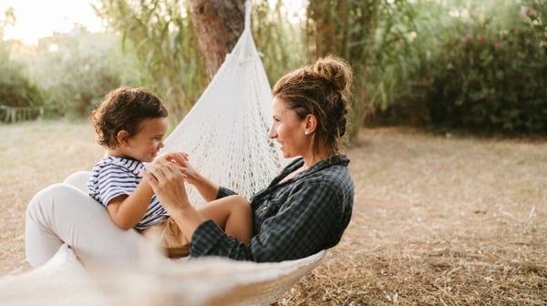 Mother and son outside sitting happily in a hammock