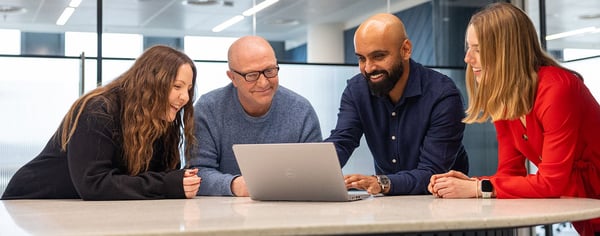 colleagues looking at laptop in the office