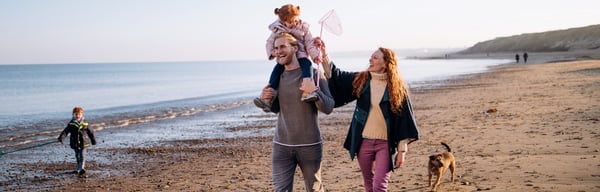 Image of family playing on the beach in autumn