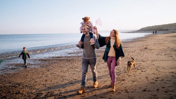 Image of family playing on the beach in autumn