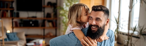 Father and young daughter hugging