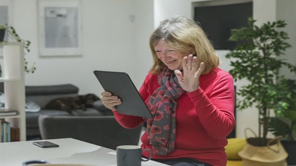 Woman waving at ipad