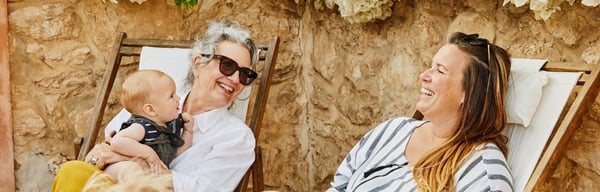 Grandmother, daughter and small children happily sitting in the garden