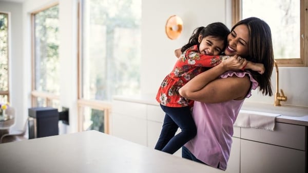 Mother and daughter hugging in the kitchen