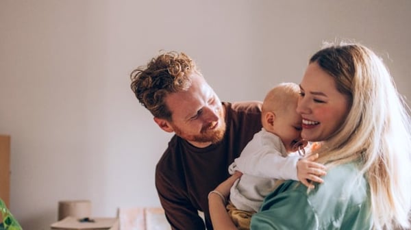 Young Mum and Dad looking happy with new baby