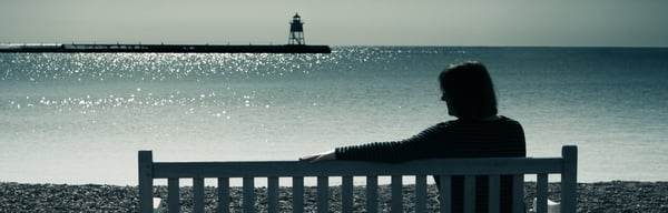 Woman sitting on a bench at the seaside