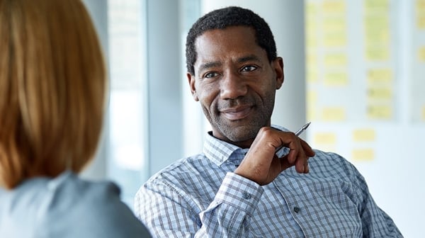 Smiling man holding pen