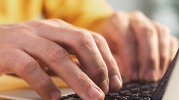 Fingers tapping on laptop
