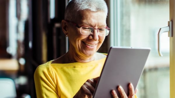 Older woman smiling at her tablet