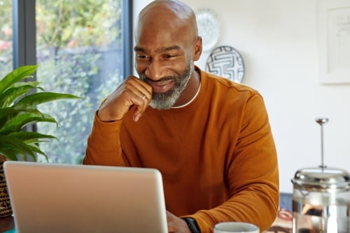 Man in his 40's working from home with laptop