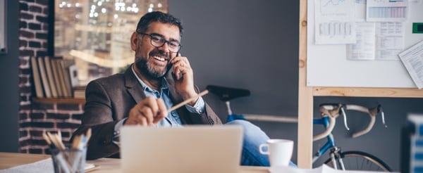 Man working on his laptop while on the phone