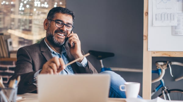 Man working on his laptop while on the phone