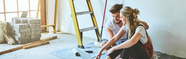 A couple sitting in a room that is being renovated
