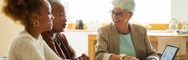 Three women talking while sat around a table