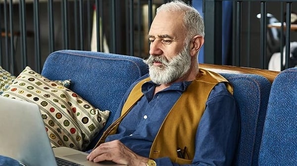 A man sitting on a sofa using a laptop