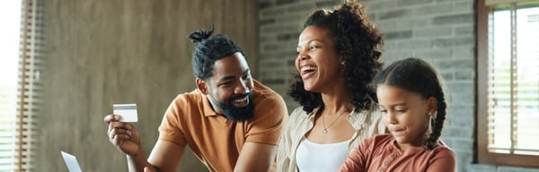 Image of family smiling together in the kitchen