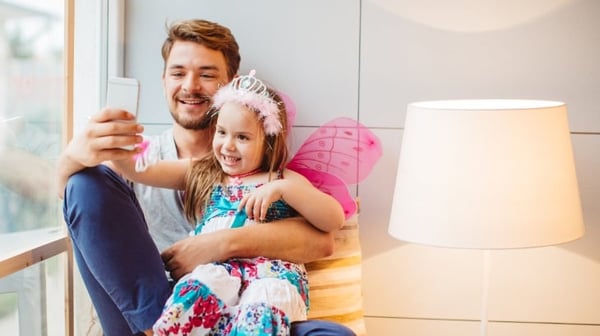 Dad and young daughter smiling and taking a selfie