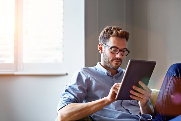 Man sitting on sofa reading ipad