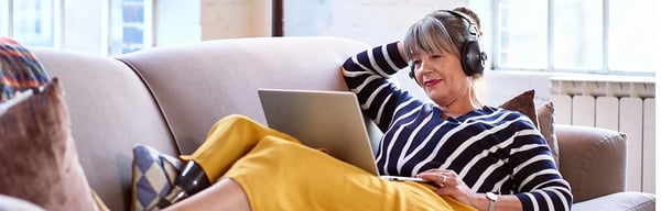 Woman lying on sofa with laptop
