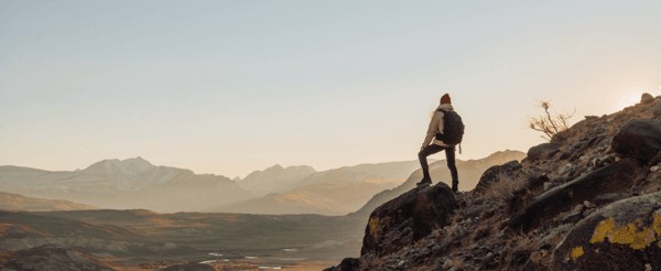 Man stands alone on a hill looking at the view