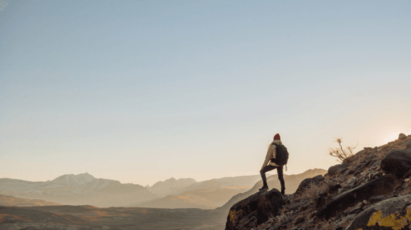 Man stands alone on a hill looking at the view