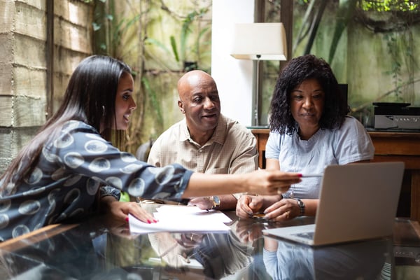 A couple talking to an adviser over a laptop