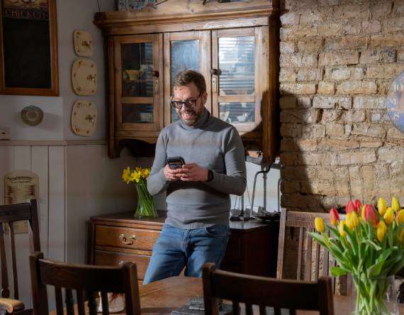 Still of Robert in kitchen, with 'Play' button overlaid