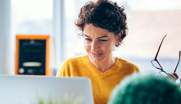 Smiling woman on laptop reviewing her options