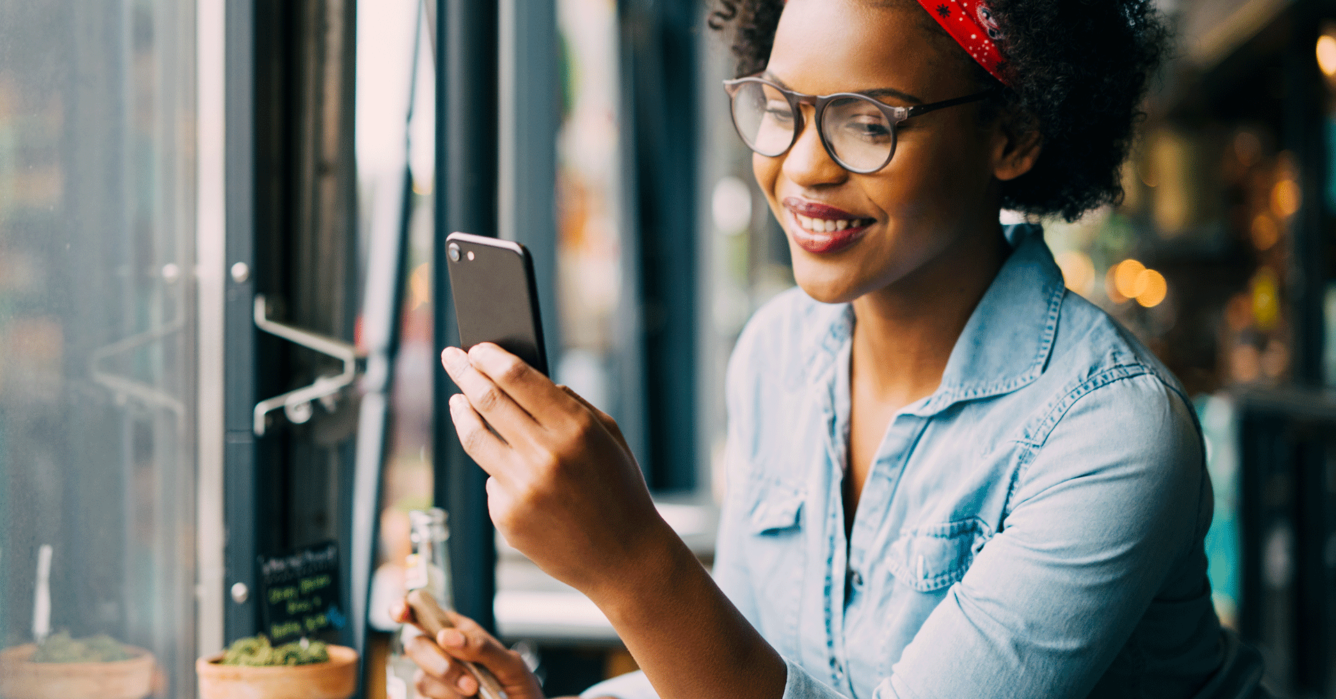 Smiling woman holding up mobile device