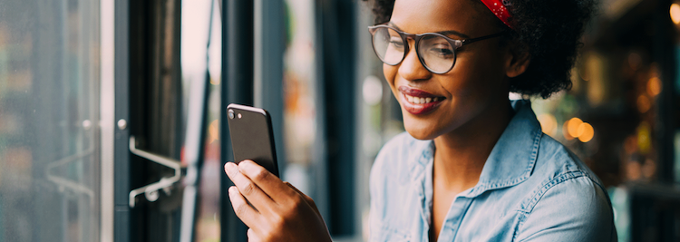 Smiling woman holding up mobile device