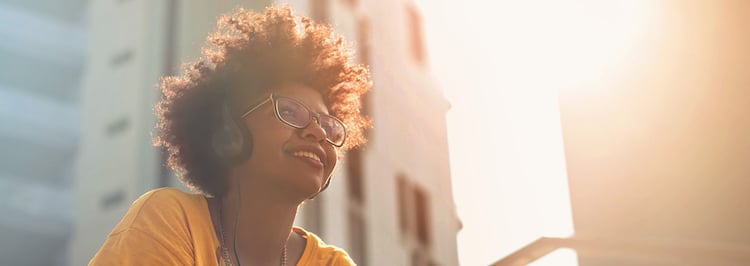 Smiling woman wearing headphones and yellow tshirt