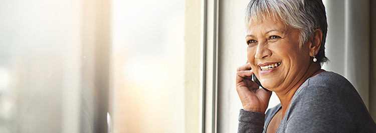 Older woman on phone looking out of window