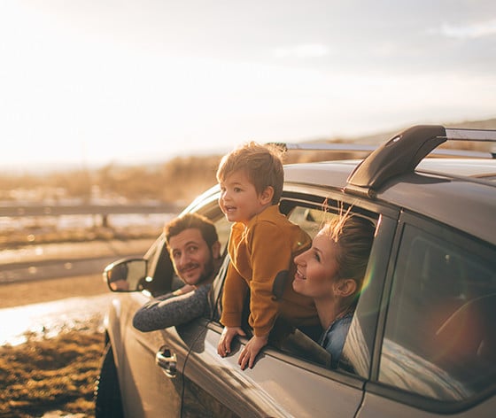 Young Family Leaning Out of Car Window