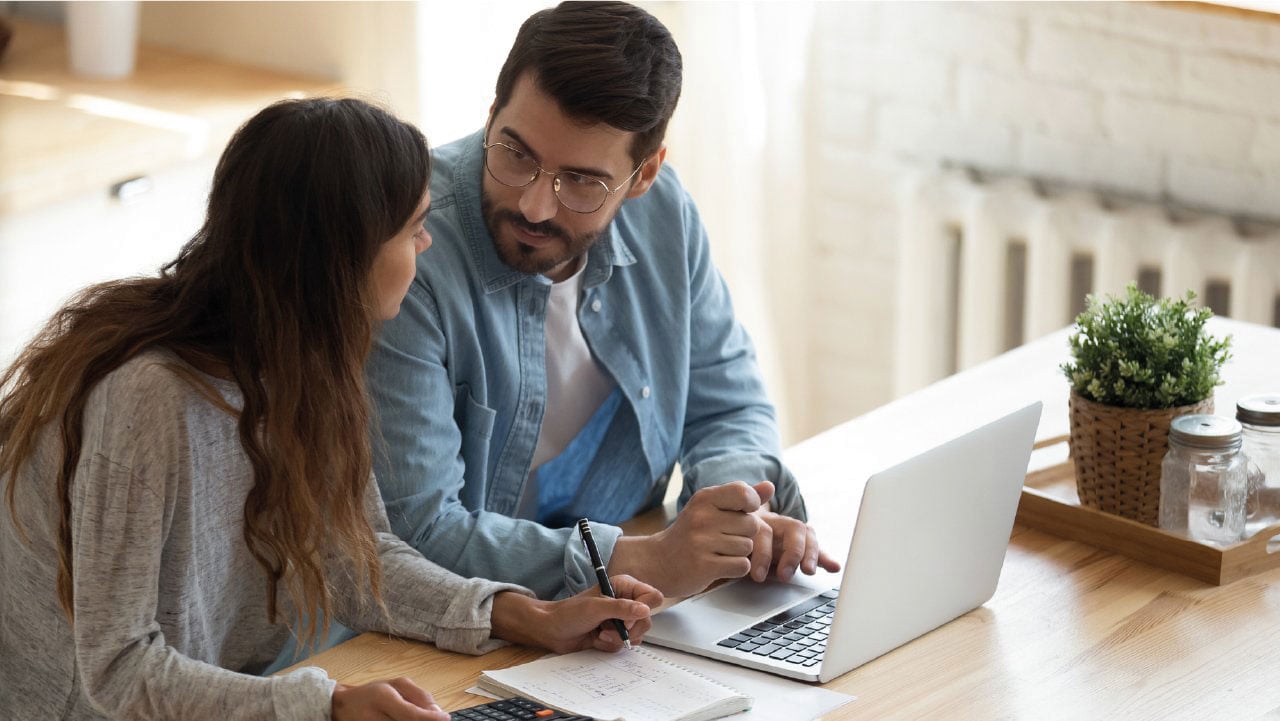 Man and woman chatting in front of laptop screen