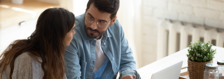 Man and woman chatting in front of laptop screen