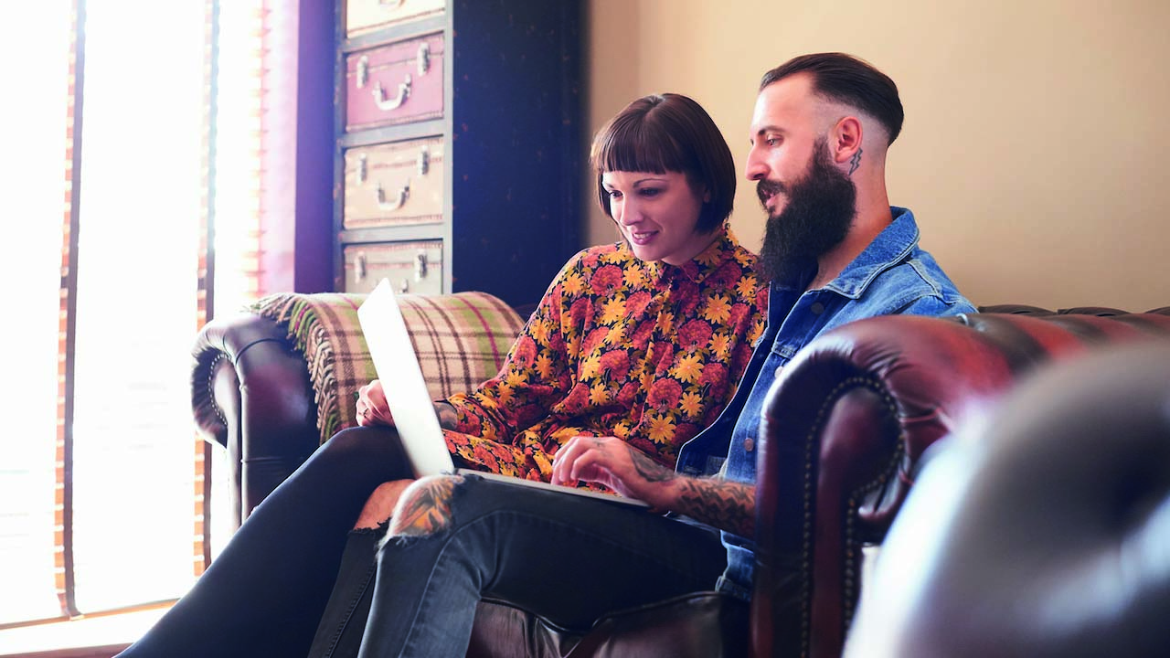 Young hipster couple looking at laptop screen