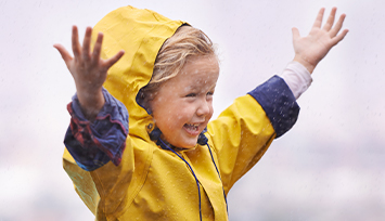 Happy girl in yellow raincoat