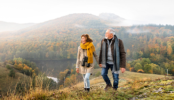 Older couple walking together in the hills