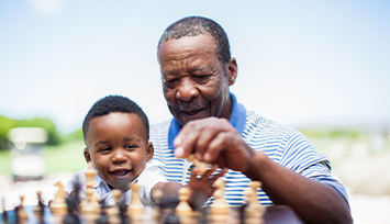Grandad and grandson playing chess together