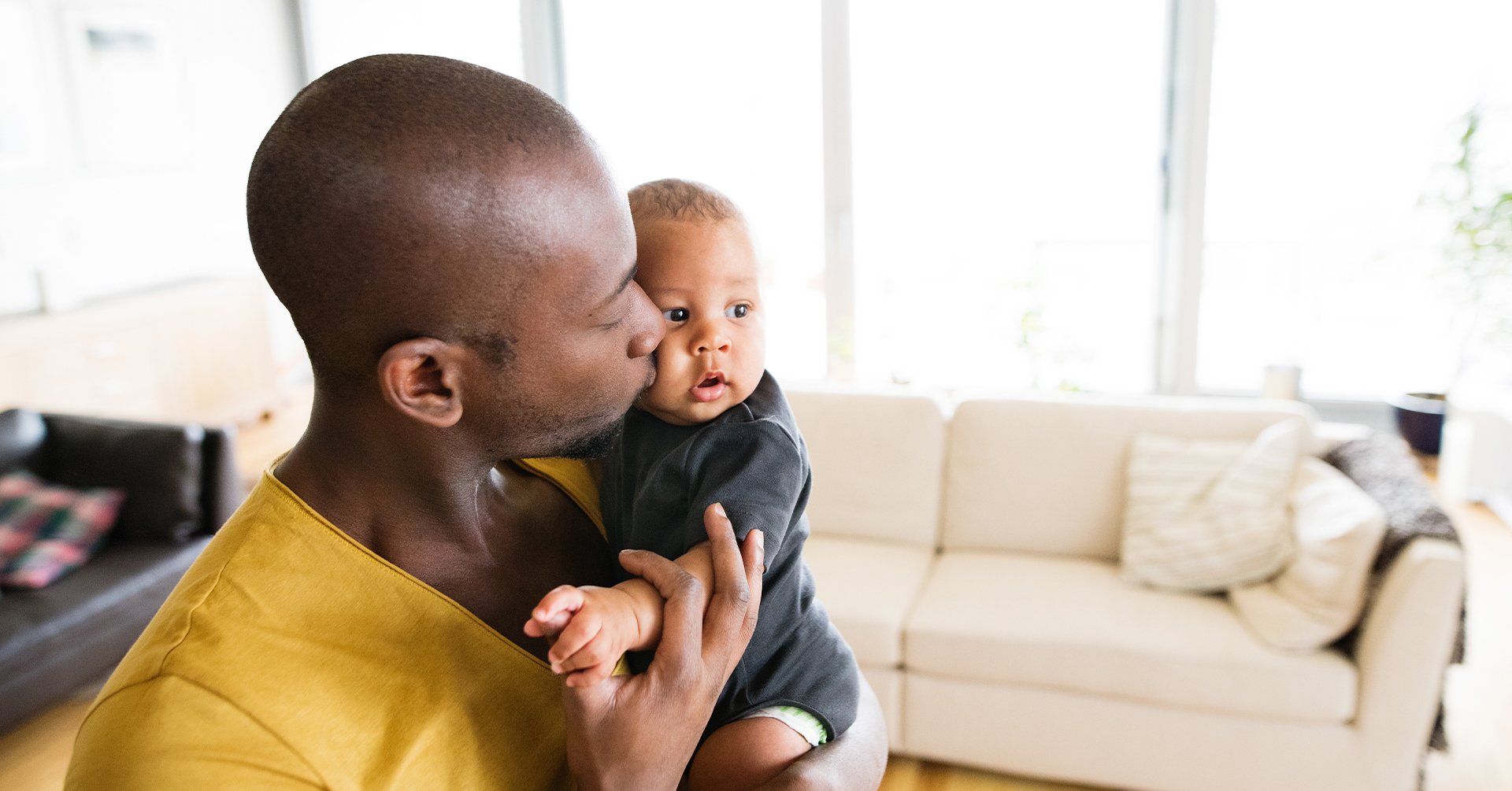 Young dad kissing his baby