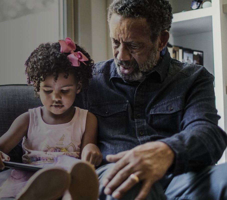 Granddaughter and grandad reading together