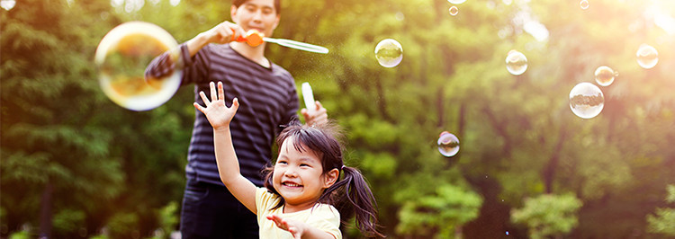 Father  and daughter playing with bubbles