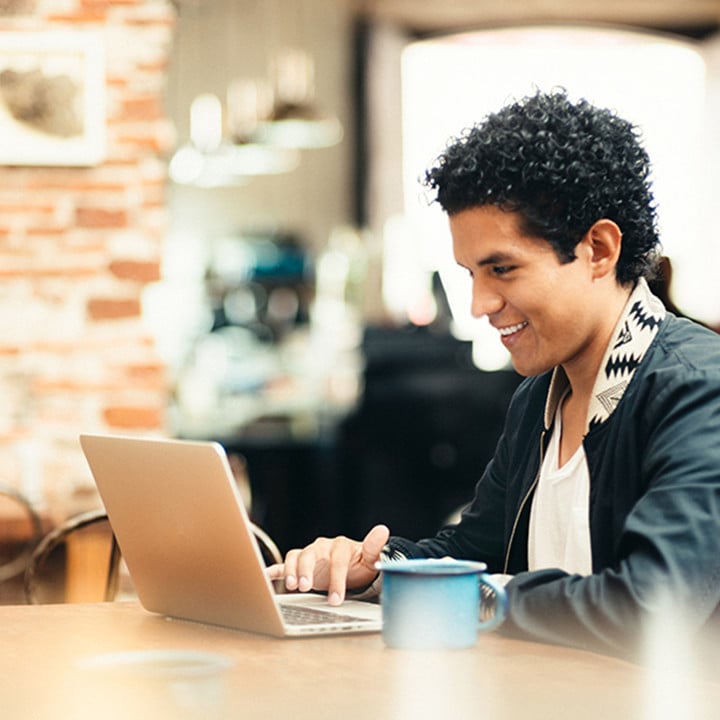 Young man on laptop in coffee shop