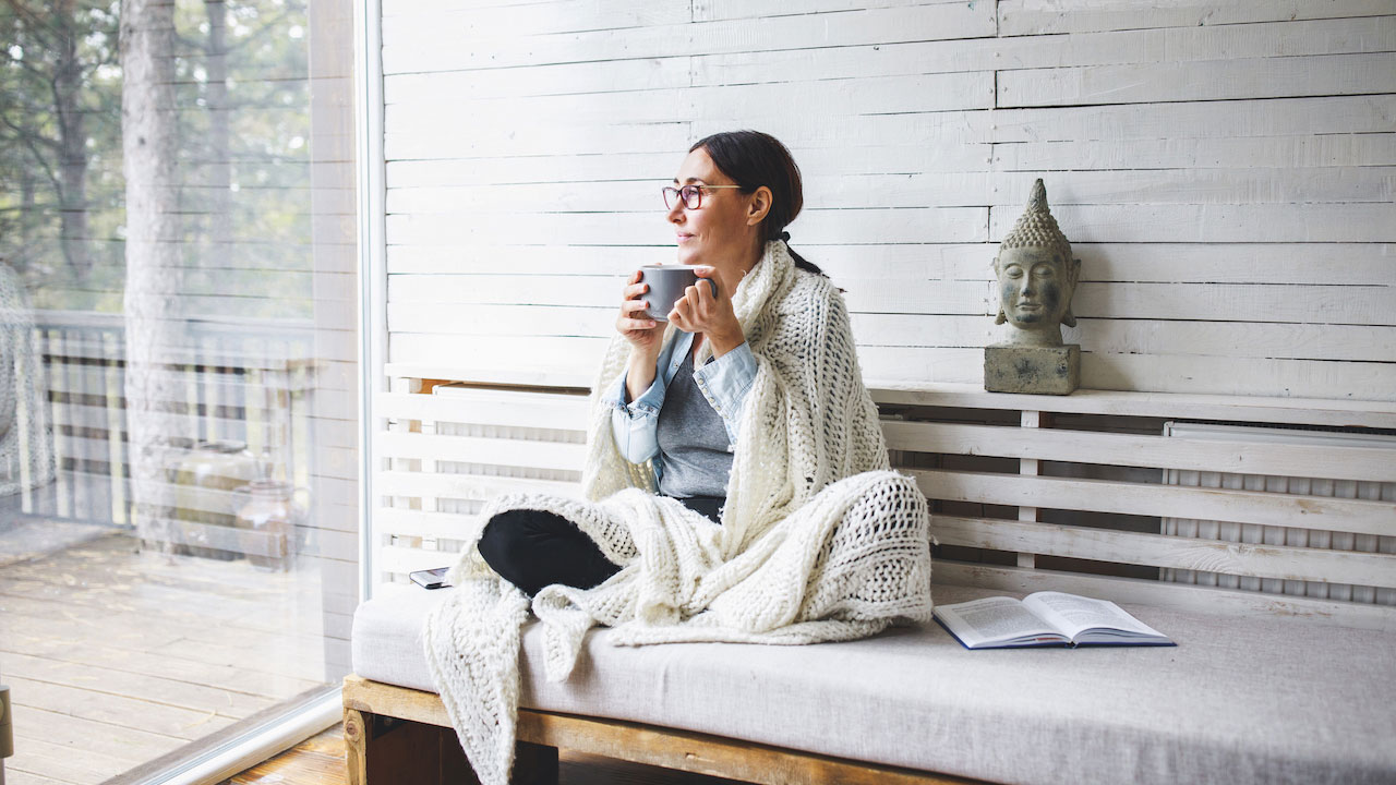 Woman with cup looking out of window